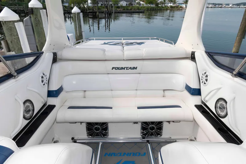 Slide: The Image of 1999 Fountain 47 Lightning boat interior with white seating and blue accents at a dock. - 15