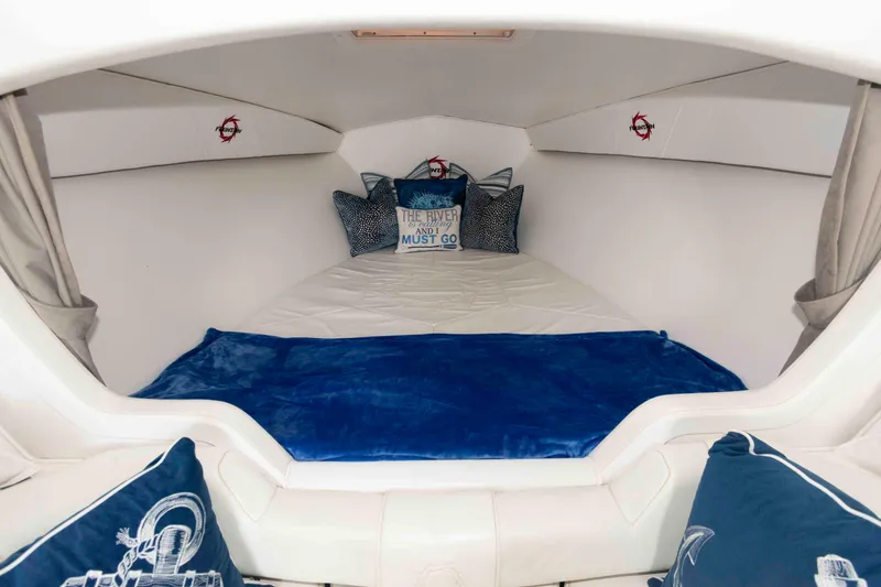 Slide: The Image of Cozy cabin interior of 1999 Fountain 47 Lightning boat with plush bedding and nautical decor. - 22