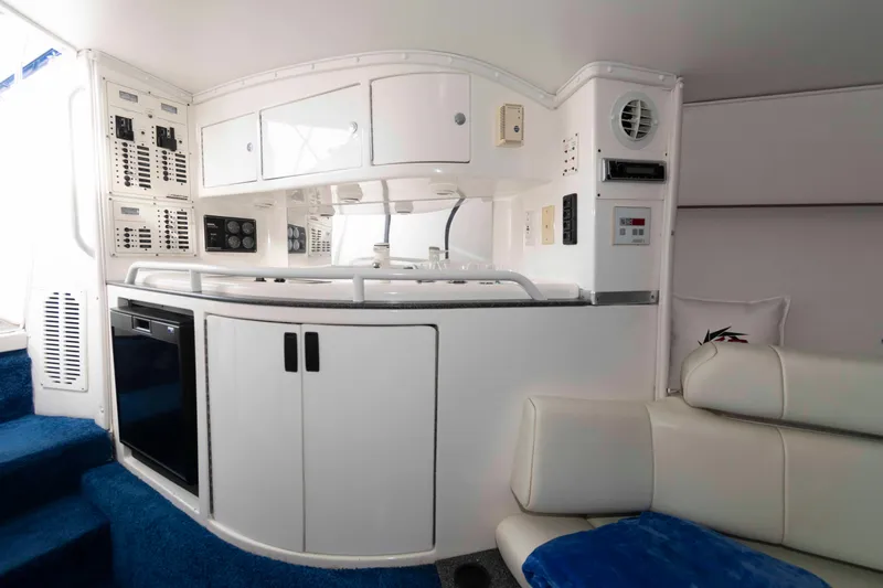Slide: The Image of Interior of 1999 Fountain 47 Lightning boat with white cabinetry and blue carpet. - 23