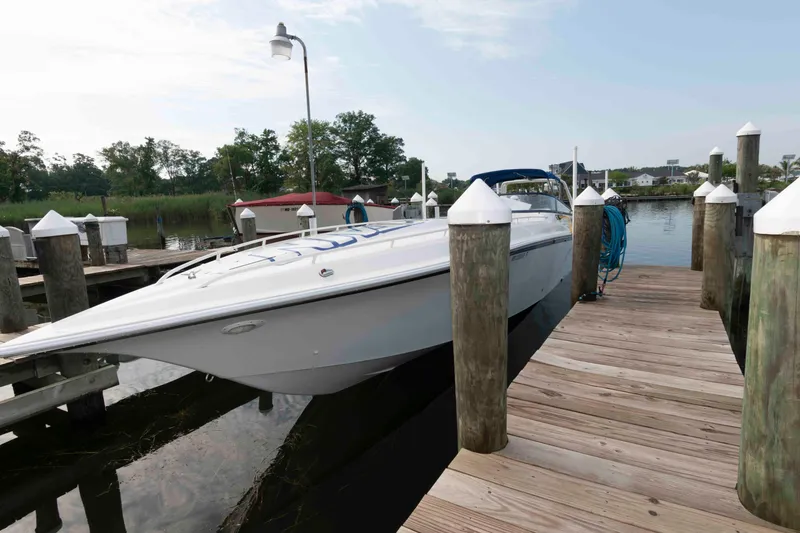 Slide: The Image of 1999 Fountain 47 Lightning boat docked at a marina, surrounded by wooden piers. - 5