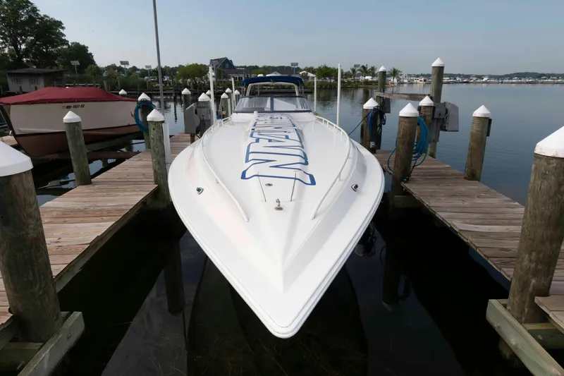 Slide: The Image of 1999 Fountain 47 Lightning speedboat docked at a marina, showcasing sleek design and powerful build. - 6