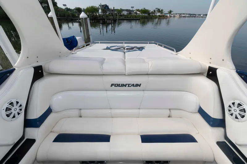 Slide: The Image of 1999 Fountain 47 Lightning boat interior with white seating, docked by calm waters. - 8