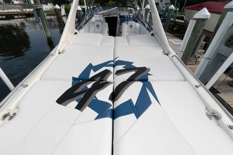 Slide: The Image of 1999 Fountain 47 Lightning boat with white seating and blue-black design, docked at marina. - 9