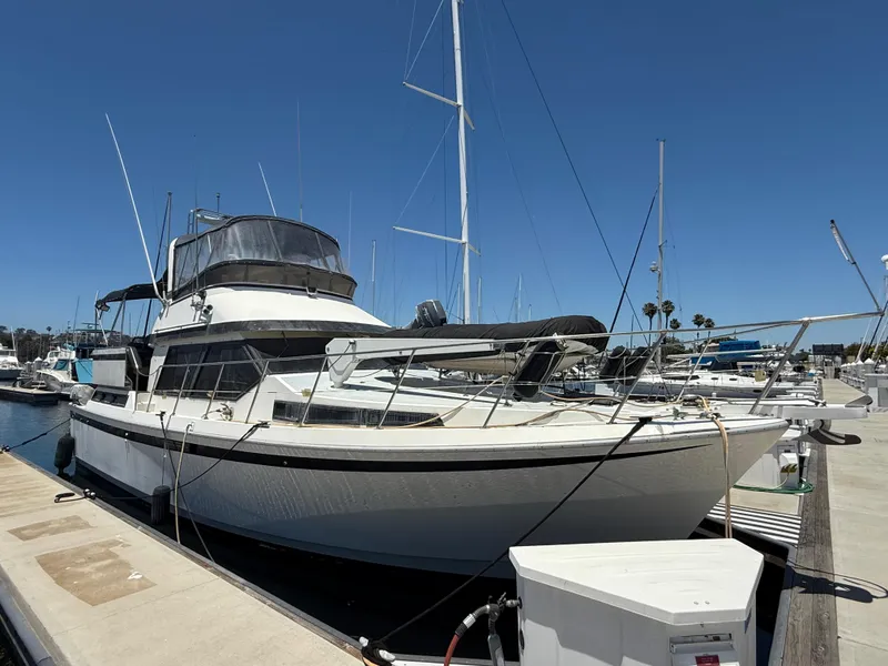The Image of 1986 Kha Shing Nautique yacht docked at marina under clear blue sky. - 1