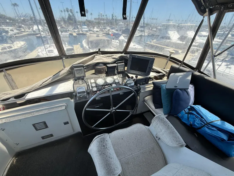 Slide: The Image of 1986 Kha Shing Nautique boat cockpit with steering wheel, navigation equipment, and marina view. - 12