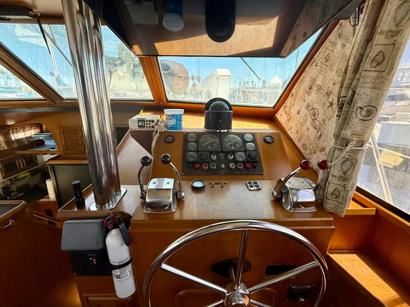 Slide: The Image of 1986 Kha Shing Nautique helm with steering wheel, control panel, and nautical instruments. - 16