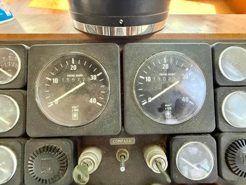 Slide: The Image of 1986 Kha Shing Nautique dashboard with engine hour meters and compass. - 17