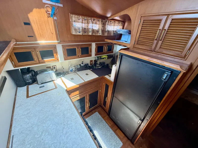 Slide: The Image of 1986 Kha Shing Nautique yacht kitchen with wooden cabinets and modern appliances. - 19