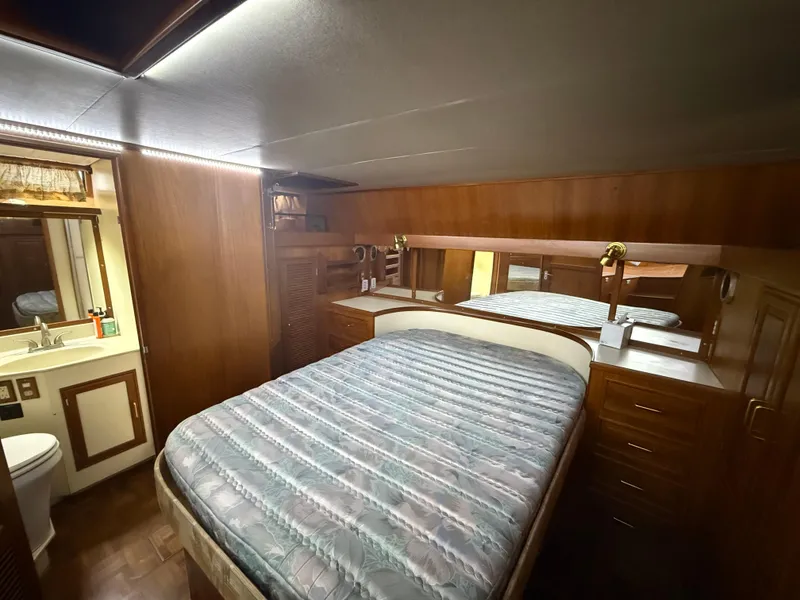 Slide: The Image of 1986 Kha Shing Nautique yacht bedroom with wood paneling and cozy bed. - 21