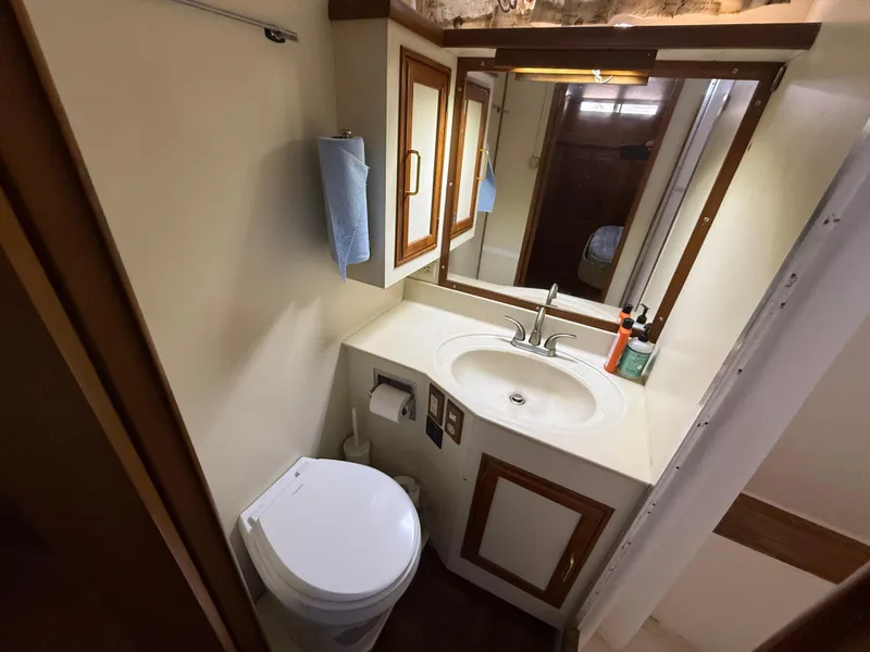 Slide: The Image of 1986 Kha Shing Nautique yacht bathroom with sink, mirror, and toilet. - 23