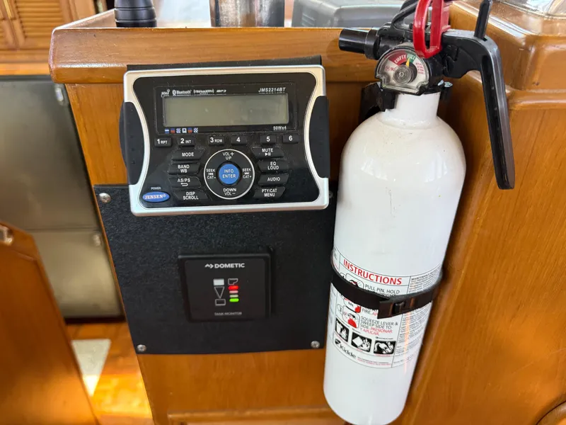 Slide: The Image of Boat interior with radio, fire extinguisher, and control panel on Kha Shing Nautique 1986. - 26