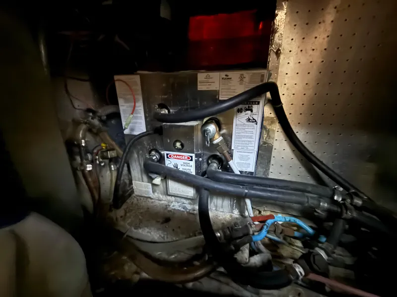 Slide: The Image of Engine compartment of a 1986 Kha Shing Nautique boat, featuring wiring and warning labels. - 29