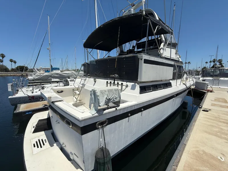 Slide: The Image of 1986 Kha Shing Nautique yacht docked at marina under clear blue sky. - 3