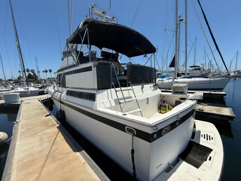 Slide: The Image of 1986 Kha Shing Nautique yacht docked at marina under clear blue sky. - 4