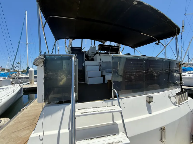 Slide: The Image of 1986 Kha Shing Nautique yacht with covered deck, docked at marina. - 5