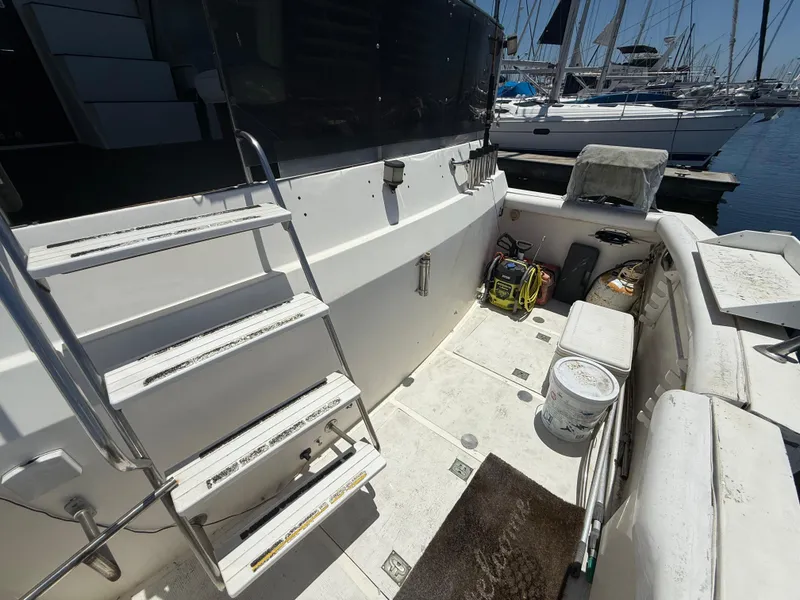 Slide: The Image of 1986 Kha Shing Nautique boat deck with ladder and equipment, docked at marina. - 6