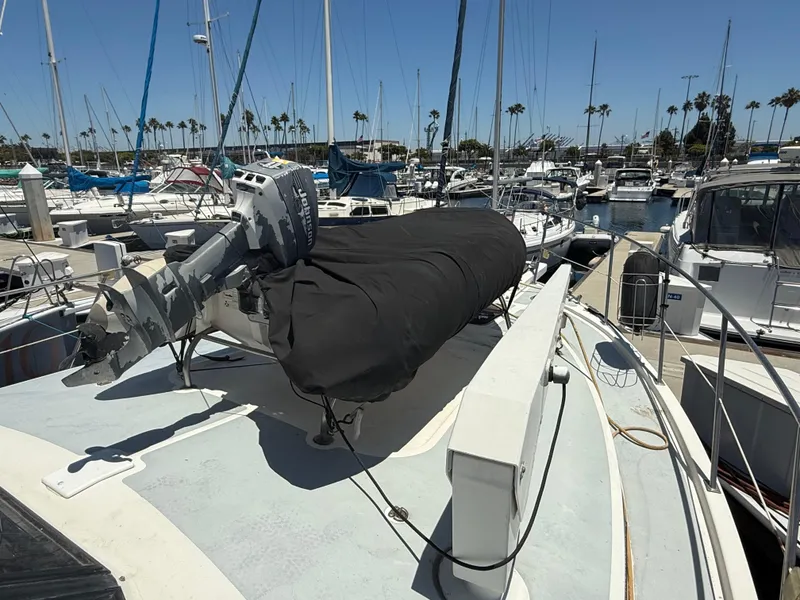 Slide: The Image of 1986 Kha Shing Nautique boat docked in marina, featuring covered equipment and outboard motor. - 9