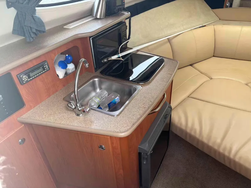 Slide: The Image of Interior of a 2006 Bayliner 245 boat with kitchenette and seating area. - 3