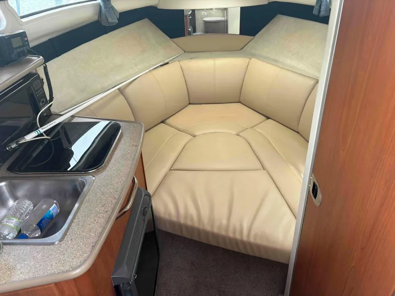 Slide: The Image of Interior of 2006 Bayliner 245 boat with beige seating and kitchenette. - 4