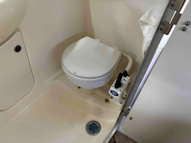 Slide: The Image of 2006 Bayliner 245 boat bathroom with compact marine toilet and pump system. - 5