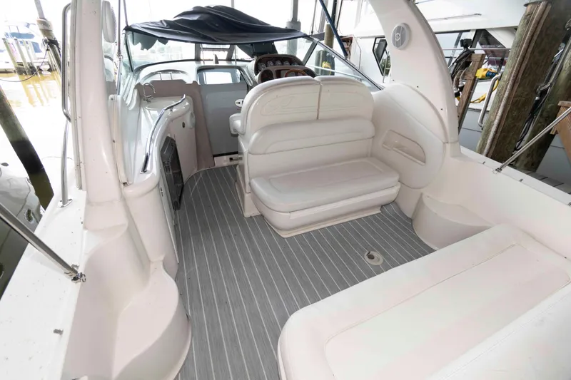 Slide: The Image of 2005 Sea Ray 300 Sundancer boat interior with white seating and gray flooring. - 10