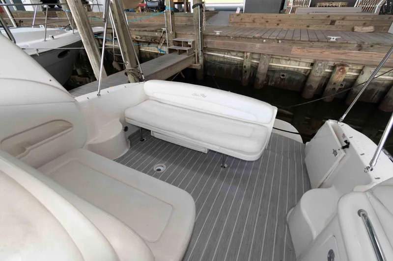 Slide: The Image of 2005 Sea Ray 300 Sundancer boat interior with white seating and gray flooring. - 11