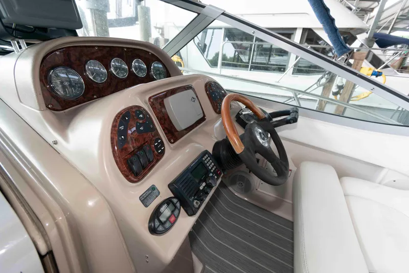 Slide: The Image of 2005 Sea Ray 300 Sundancer helm with wood accents and modern controls. - 14