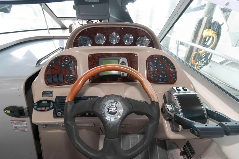 Slide: The Image of Helm of 2005 Sea Ray 300 Sundancer with wood accents and modern controls. - 15