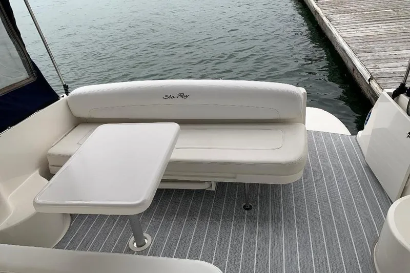Slide: The Image of 2005 Sea Ray 300 Sundancer boat interior with seating and table by the water. - 17