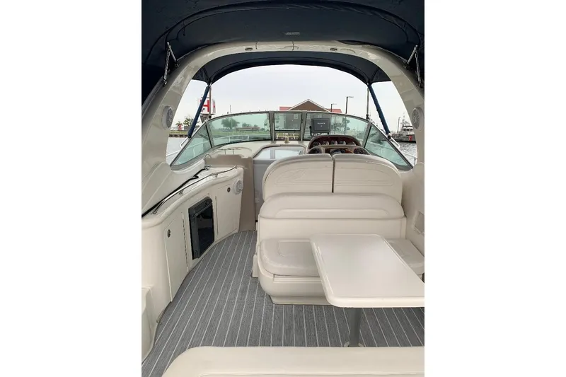 Slide: The Image of 2005 Sea Ray 300 Sundancer interior with seating and table, docked at marina. - 18
