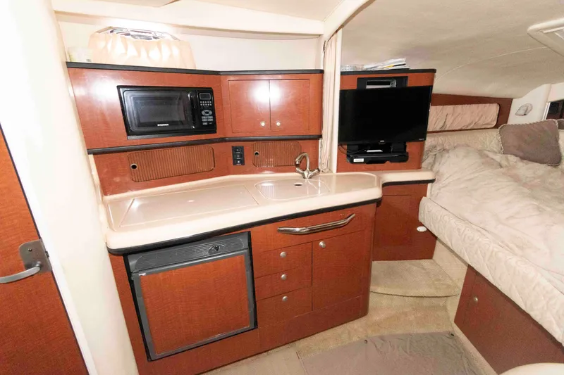 Slide: The Image of Interior of 2005 Sea Ray 300 Sundancer with kitchenette and cozy sleeping area. - 20