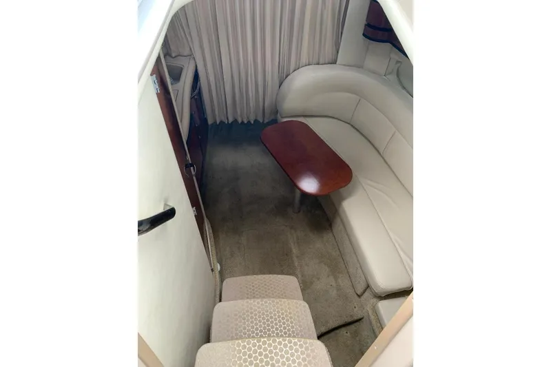 Slide: The Image of Interior of 2005 Sea Ray 300 Sundancer with beige seating and wooden table. - 24