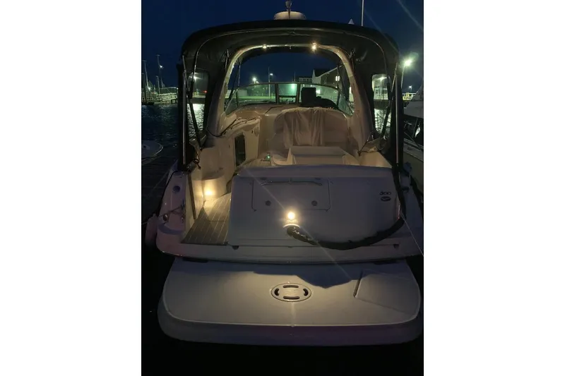 Slide: The Image of 2005 Sea Ray 300 Sundancer yacht illuminated at night, docked in a marina. - 28