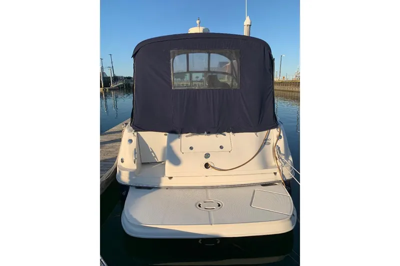 Slide: The Image of 2005 Sea Ray 300 Sundancer boat docked, rear view with blue canvas cover. - 7