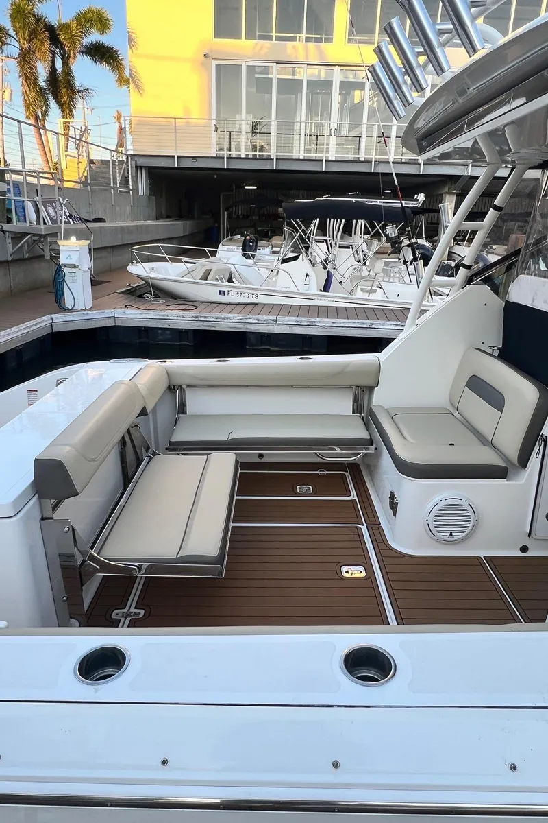 Slide: The Image of 2019 Pursuit 325 DC boat interior with seating, docked at marina. - 14