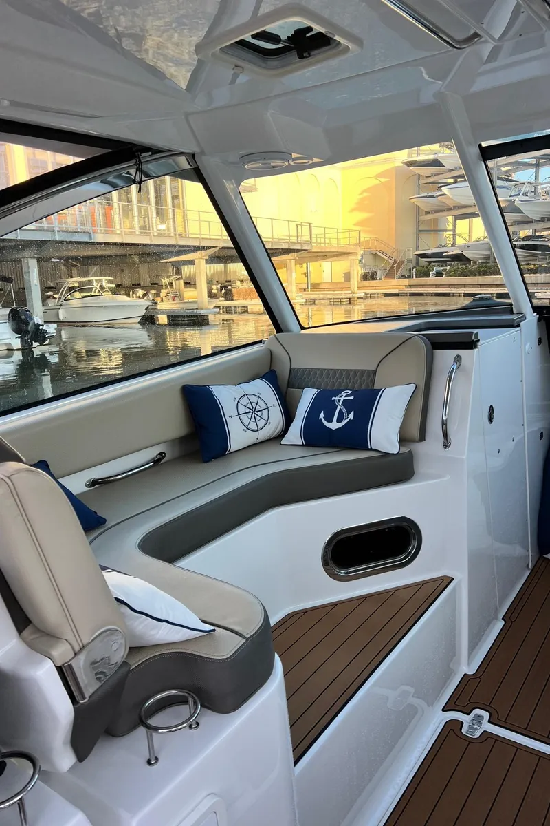 Slide: The Image of Interior of a 2019 Pursuit 325 DC boat with nautical-themed cushions. - 15