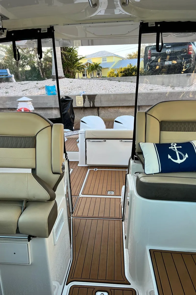 Slide: The Image of 2019 Pursuit 325 DC boat interior with tan seating and nautical-themed decor. - 8