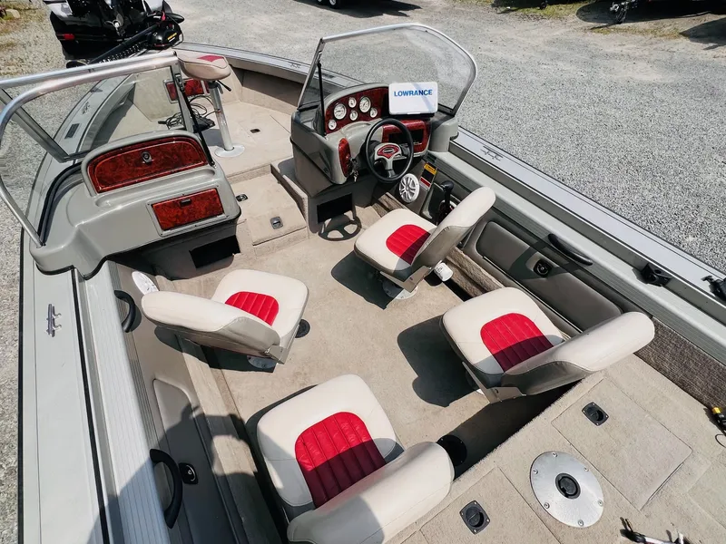 Slide: The Image of 2004 Tracker Targa WT boat interior with red and white seating, steering wheel, and dashboard. - 13
