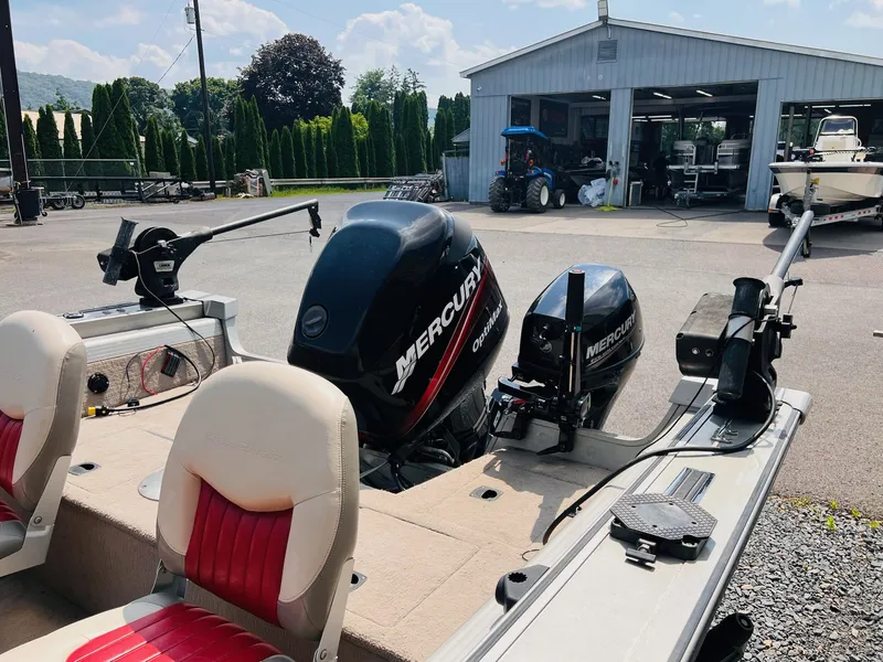 Slide: The Image of 2004 Tracker Targa WT boat with Mercury engines, parked near a workshop. - 31
