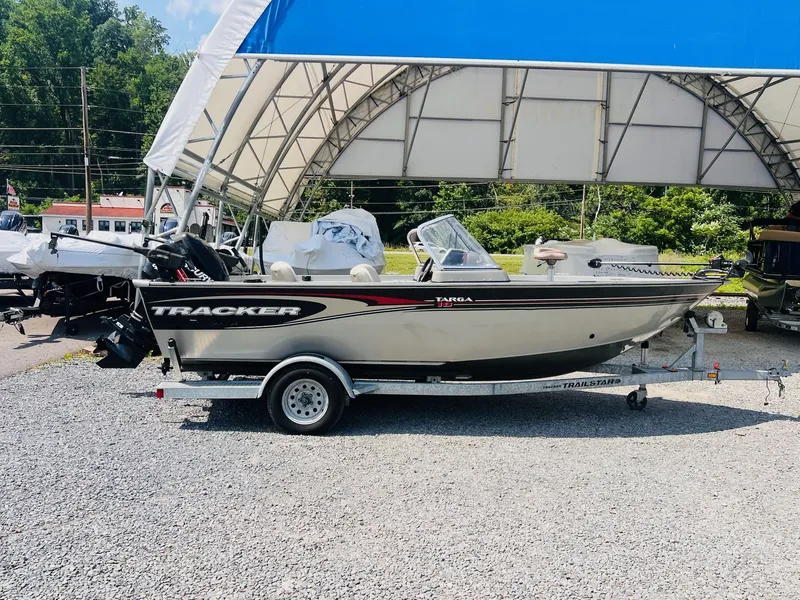 Slide: The Image of 2004 Tracker Targa WT boat on trailer under canopy, parked on gravel. - 33