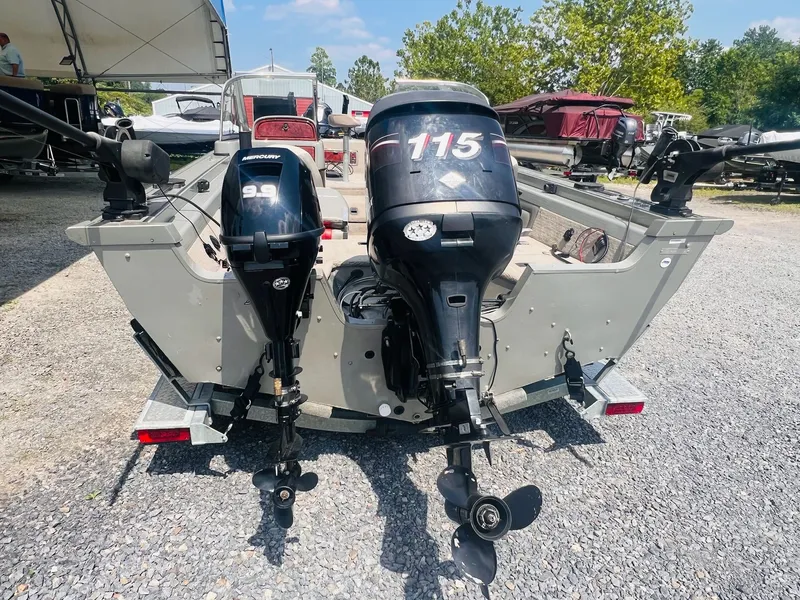 Slide: The Image of 2004 Tracker Targa WT boat with dual Mercury outboard motors, parked on gravel. - 39