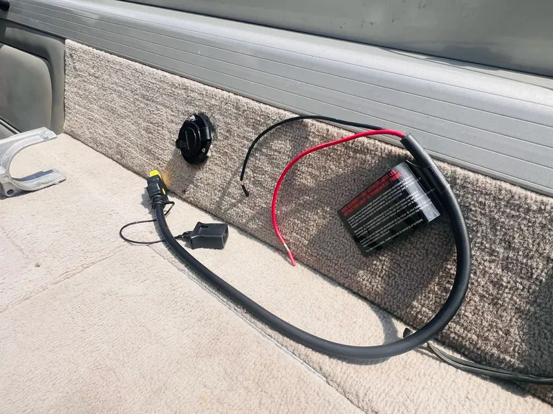 Slide: The Image of 2004 Tracker Targa WT interior with wiring and battery components on carpeted surface. - 5