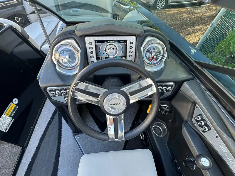 Slide: The Image of 2013 Supra SA350 boat dashboard with steering wheel and gauges. - 16