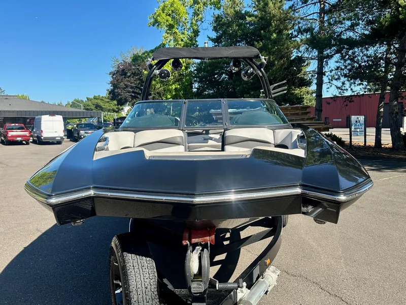 Slide: The Image of 2013 Supra SA350 boat on trailer, parked outdoors, with trees and vehicles in the background. - 4