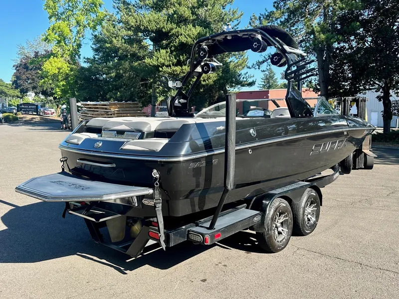 Slide: The Image of 2013 Supra SA350 boat on trailer, parked outdoors with trees in background. - 7