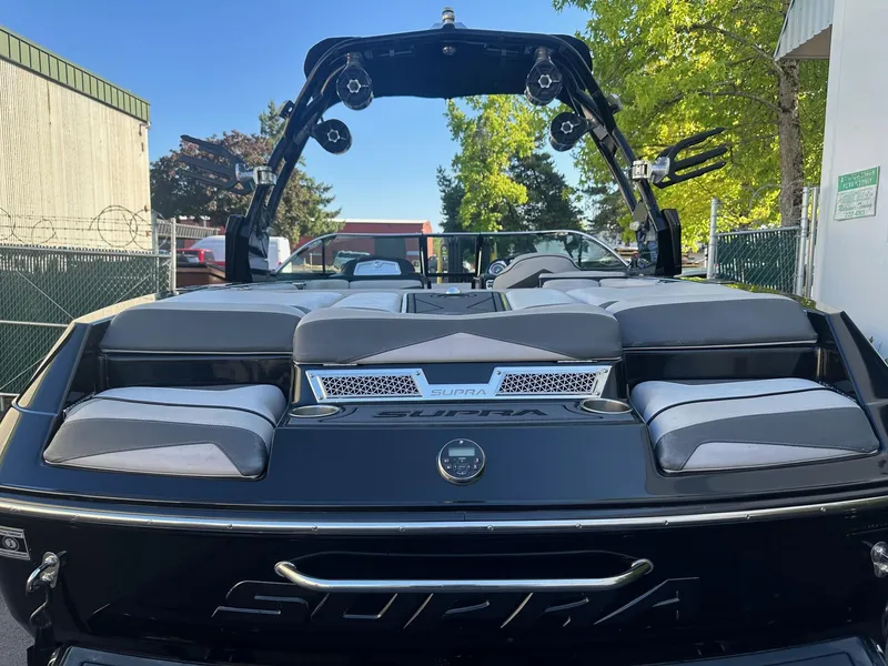 Slide: The Image of 2013 Supra SA350 boat with sleek design and comfortable seating, parked outdoors. - 9