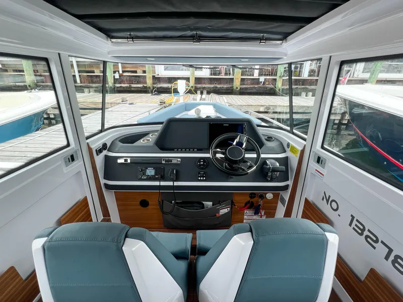 Slide: The Image of Interior view of 2022 Axopar 28 Cabin Aft Cabin boat, featuring modern dashboard and seating. - 15