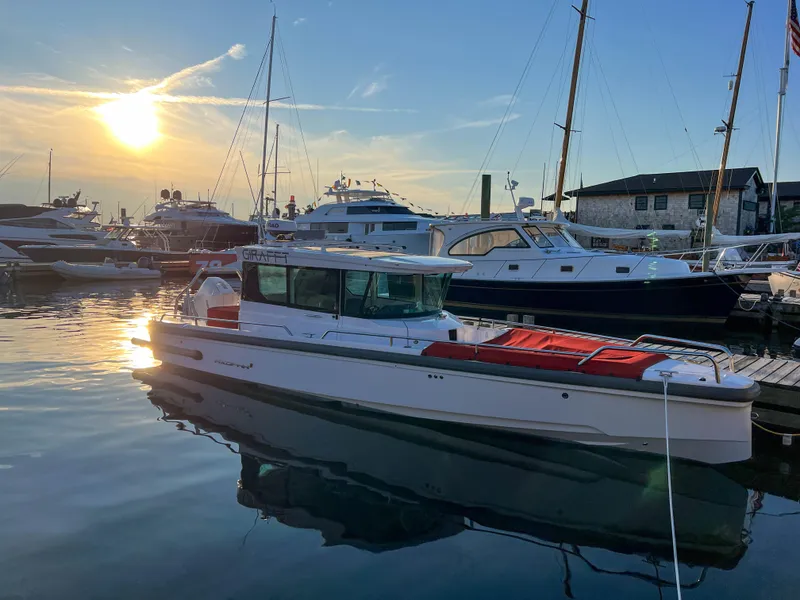 Slide: The Image of 2022 Axopar 28 Cabin Aft Cabin boat docked at sunset in a marina. - 3