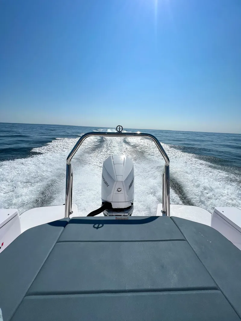 Slide: The Image of 2022 Axopar 28 Cabin Aft Cabin cruising on open water under clear blue sky. - 33