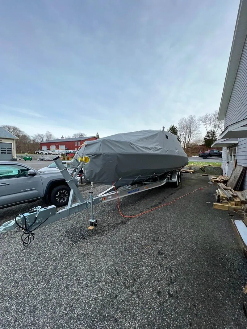 Slide: The Image of Covered 2022 Axopar 28 Cabin Aft Cabin boat on trailer in driveway. - 34